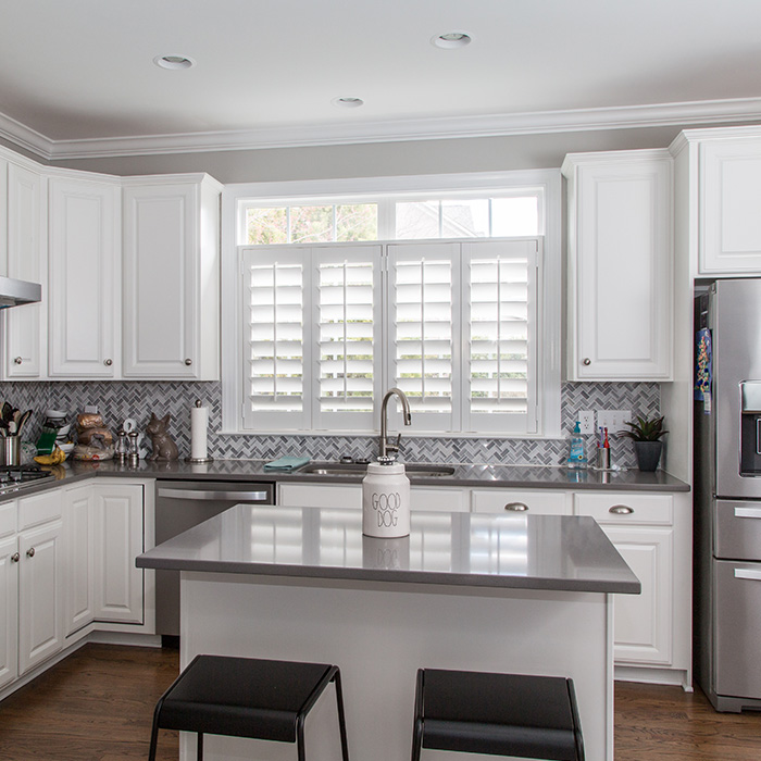 White cafe shutters above a kitchen sink.