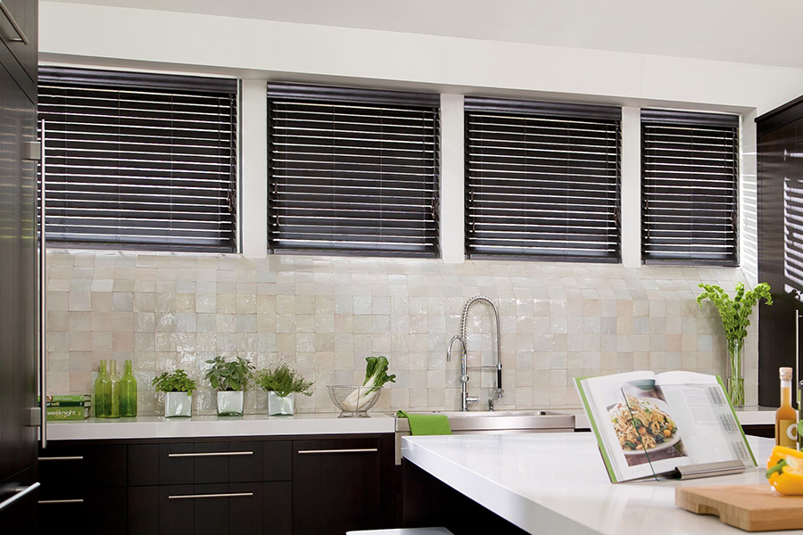 Choose custom Polywood faux wood blinds for your kitchen in Destin. Special shaped faux wood blinds in several windows above a sink.