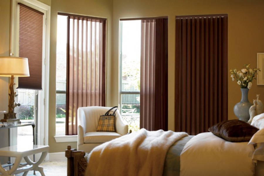 Choose durable and high-quality fabric or vinyl vertical blinds in Destin. Maroon fabric vertical blinds inside a bedroom