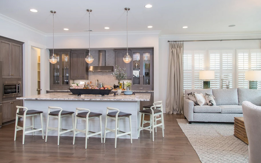 Illuminate your home with custom interior shutters in Destin. White arched shutters in a white kitchen with lots of light.