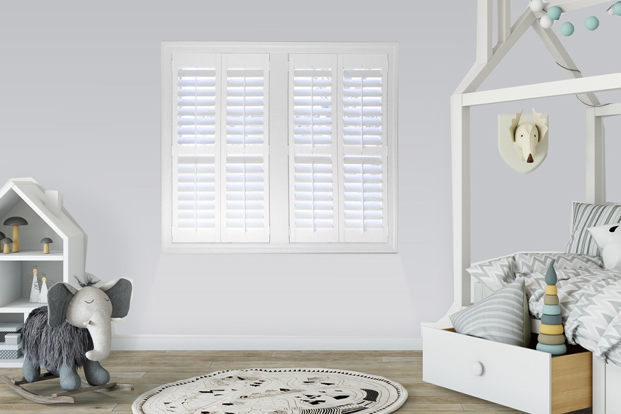 White Polywood shutters in a large nursery bedroom.