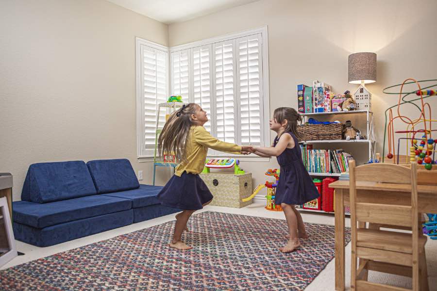 Choose Polywood shutters for durable, kid-friendly great room window treatments in Destin. Polywood shutters on multiple windows in a sitting area