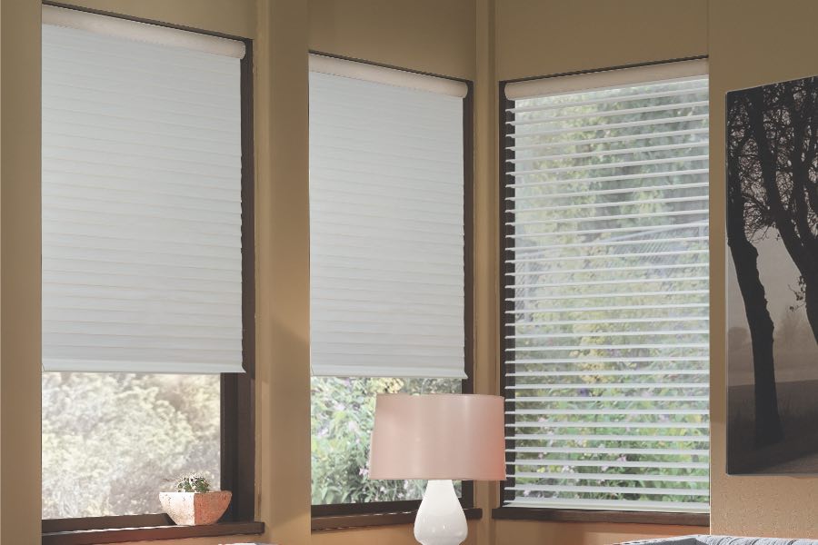 Opaque motorized window shades in Destin keep hot UV rays out of your home. Gray motorized sheer shades on corner windows next to gray furniture