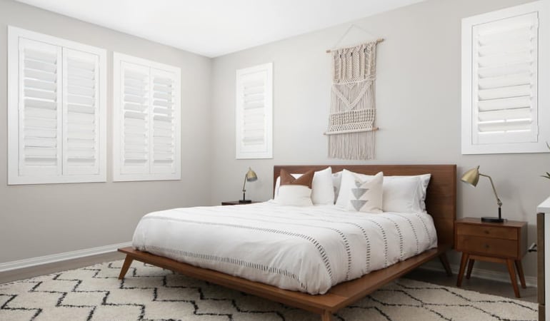 Open shutter louvers will help any Destin room feel larger. Plantation shutters in a model home bedroom.