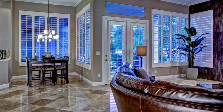 Photo Courtesy of Room Resolutions Destin great room with plantation shutters and tile floor.