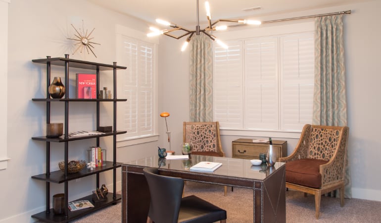 Picking the right window treatments can result in an increase in natural light. Destin home office with plantation shutters.