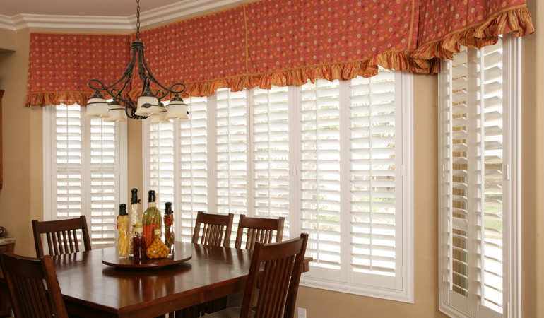 Decorative accents, drapes, and curtains may not offer the simplistic style you are going for. Plantation shutters in Destin dining room.