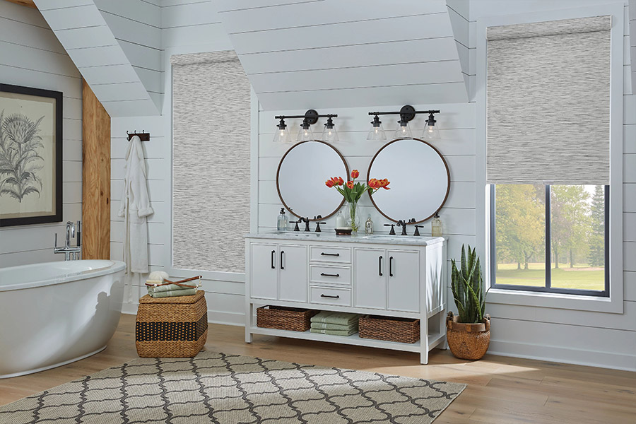 Slim-profile roller shades easily fit shallow windows in your Destin home. Gray patterned roller shades on bathroom windows